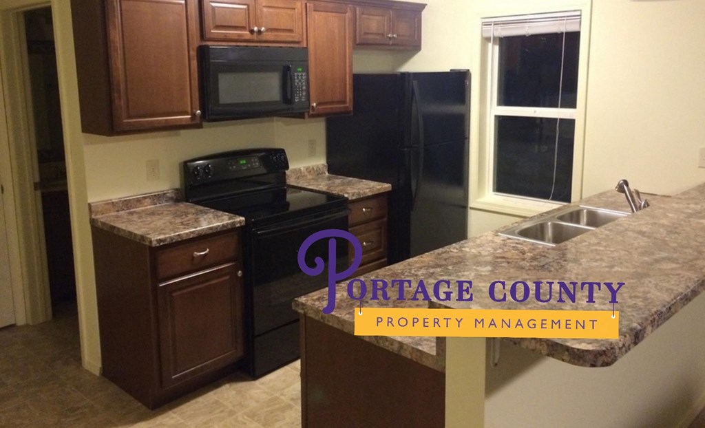 an updated kitchen with granite counter tops and black appliances