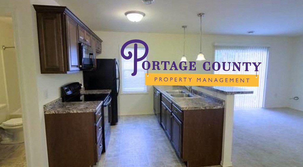an empty kitchen with the portage county property management logo