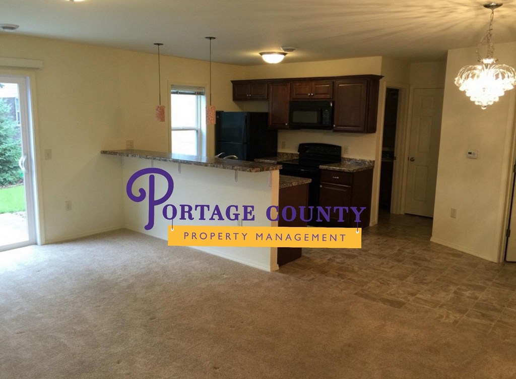 an empty kitchen and living room in a house with a property management sign