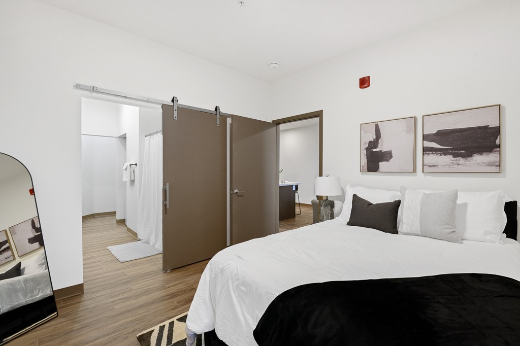 A bedroom with a large bed and a mirror on the wall.