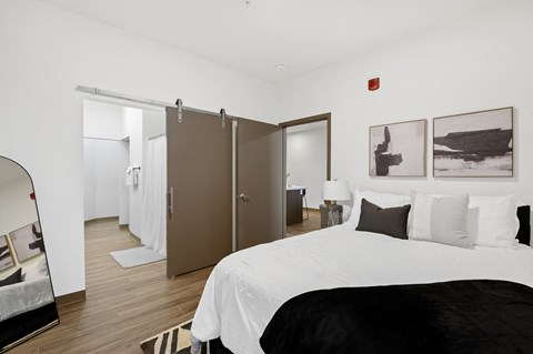A bedroom with a large bed and a mirror on the wall.