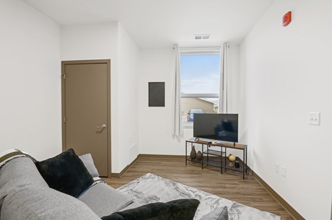 A living room with a grey couch and a flat screen TV.