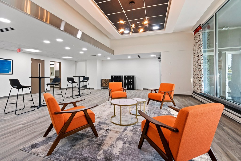 A conference room with orange chairs and a white table.