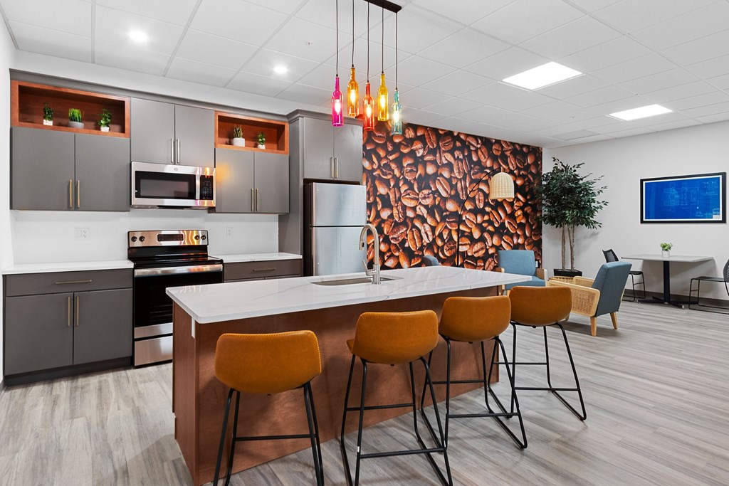 A modern kitchen with a bar area and a television in the background.