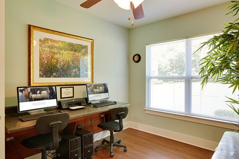 A room with a desk, chair, and computer.