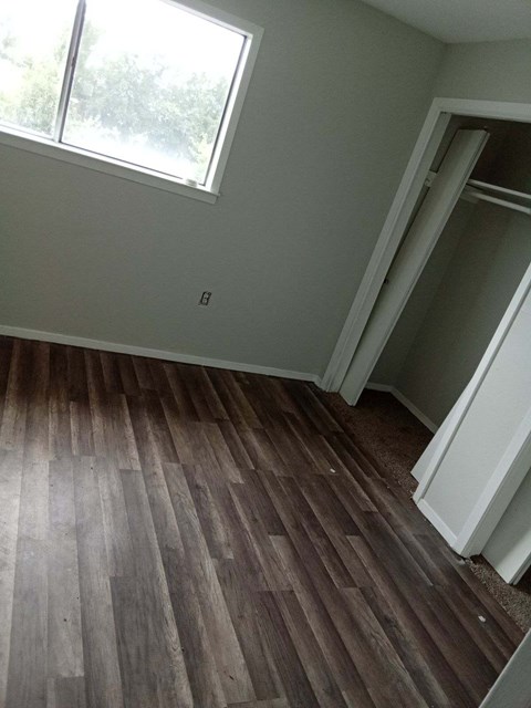 a room with a hard wood floor and a window