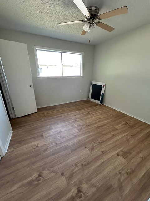 a living room with wooden floors and a ceiling fan