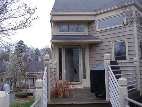 a gray house with a porch and a door
