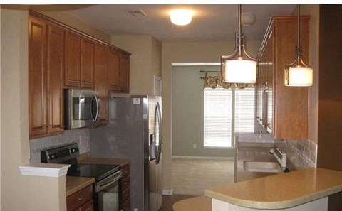A kitchen with wooden cabinets and stainless steel appliances.
