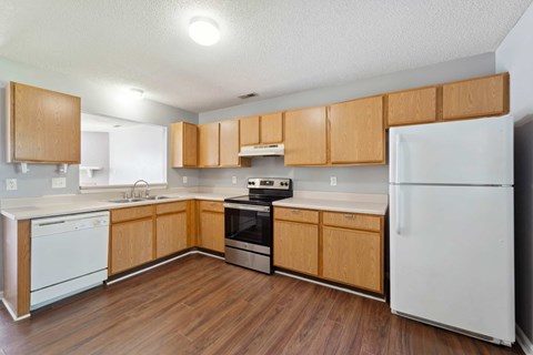 A kitchen with wooden cabinets and white appliances.