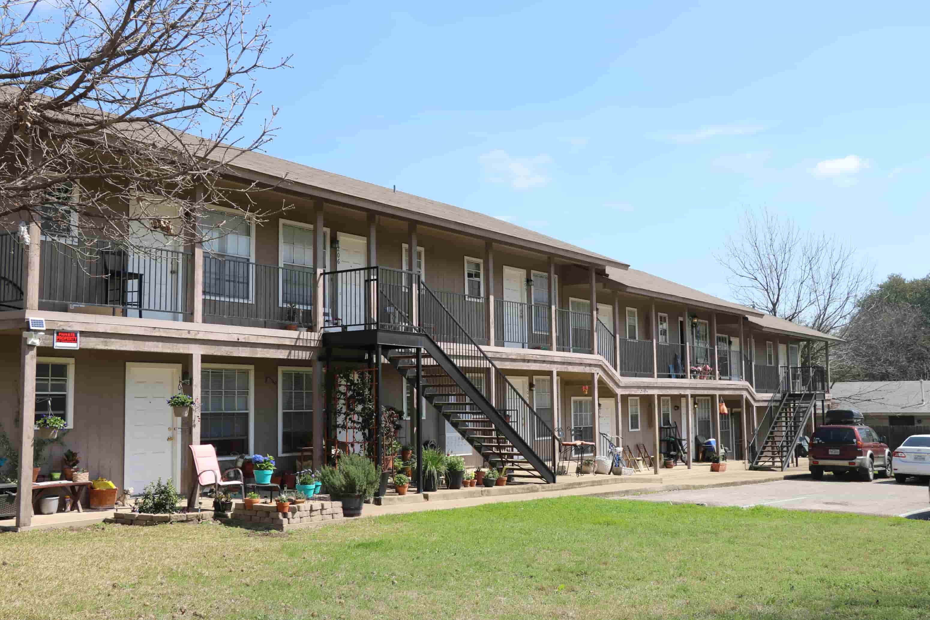 the front of a building with a porch and stairs