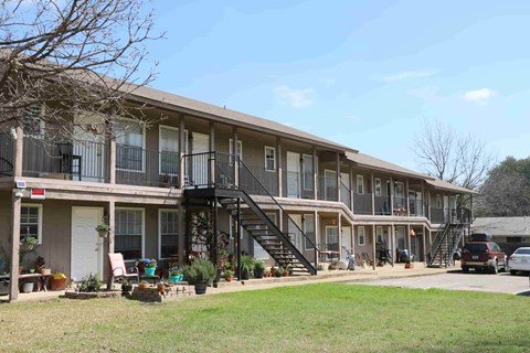 the front of a building with a porch and stairs