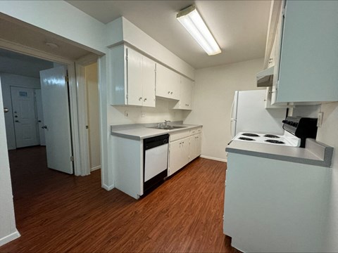 a kitchen with white cabinets and a stove and a refrigerator