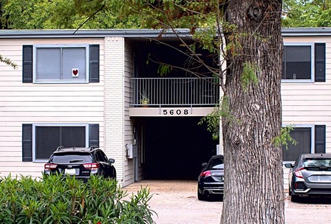 an apartment building with cars parked in front of it