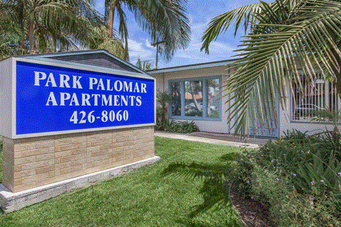 A sign for Park Palomar Apartments with a phone number on it.