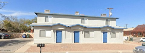 a white house with blue doors on a street