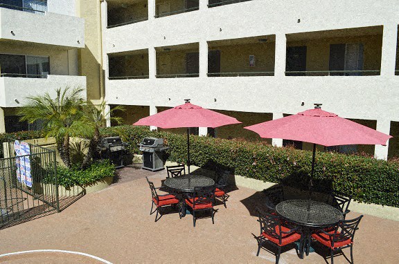 an outdoor patio with tables and pink umbrellas