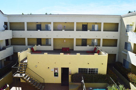 an overhead view of an apartment building with a pool