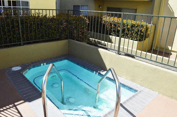a jacuzzi in a swimming pool next to a fence