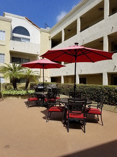 a group of tables and chairs with red umbrellas