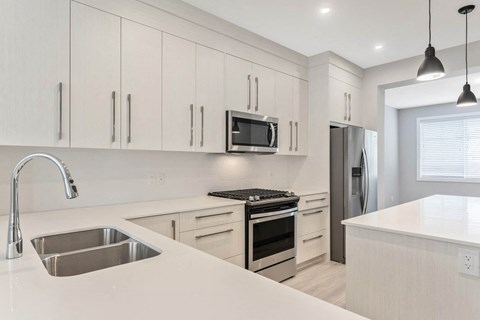 a kitchen with white cabinets and stainless steel appliances