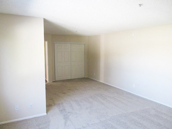 an empty living room with white walls and a white door