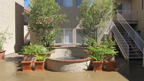 a courtyard with potted plants in front of a building