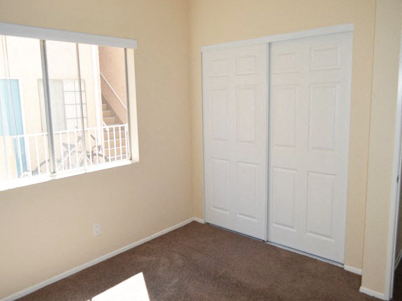 an empty room with two white doors and a window