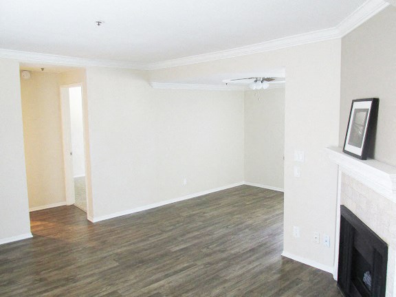 an empty living room with a fireplace and white walls