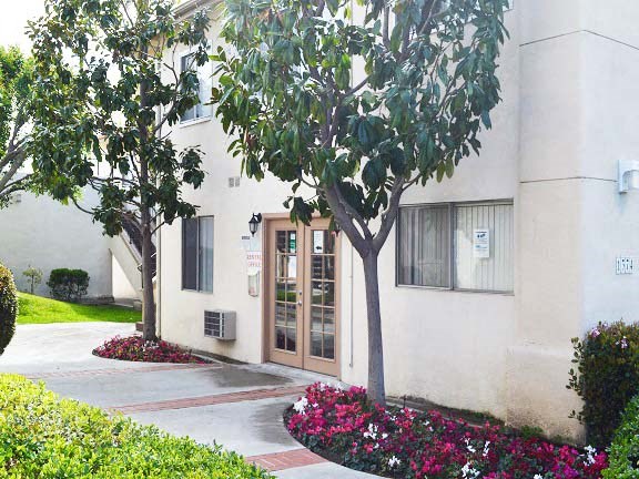 a building with a door and a tree in front of it