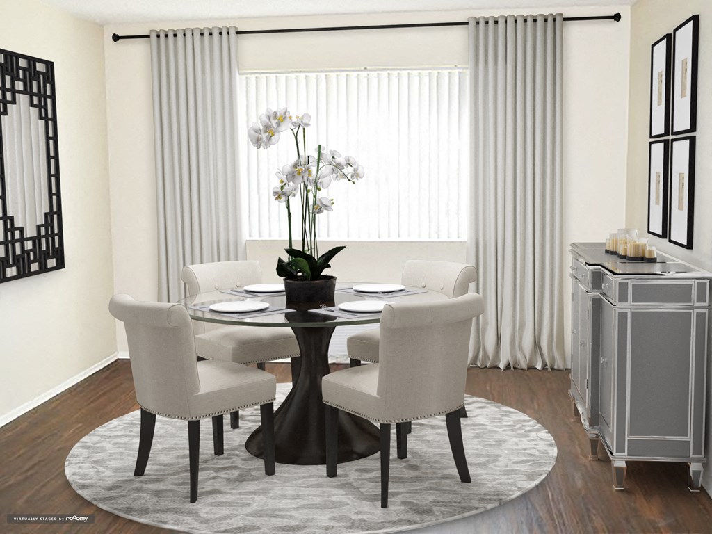 a dining room with a round table and white chairs