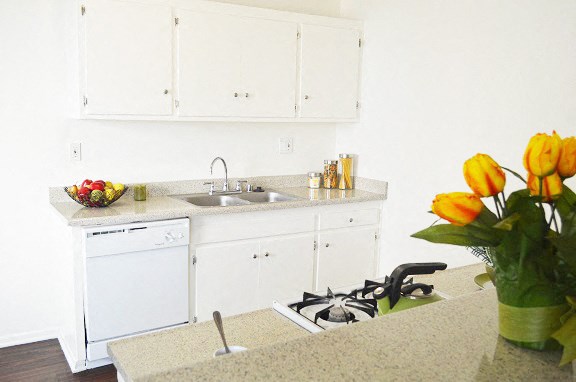 a kitchen with white cabinets and a sink and a counter