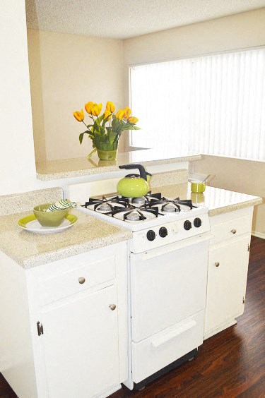 a white kitchen with a stove and a counter top