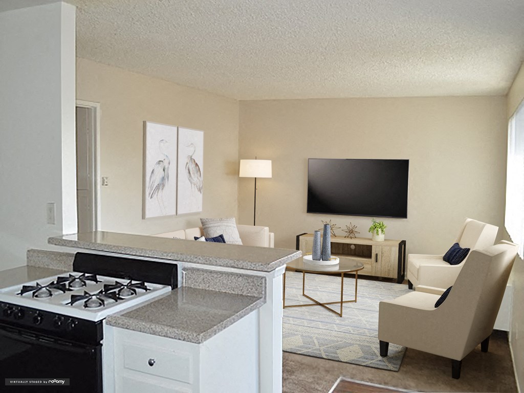 the view of the living room from the kitchen with the counter top and a stove