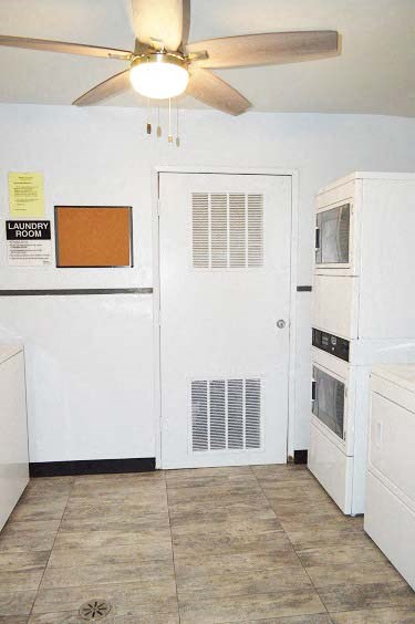 a kitchen with a white refrigerator and a ceiling fan