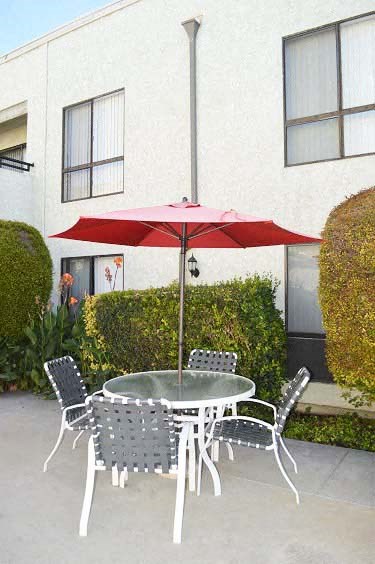 a patio table with a red umbrella and chairs