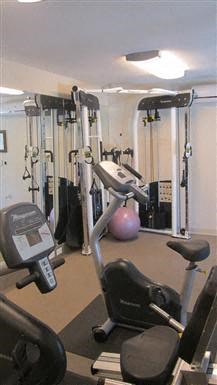 a gym with various machines and weights in it
