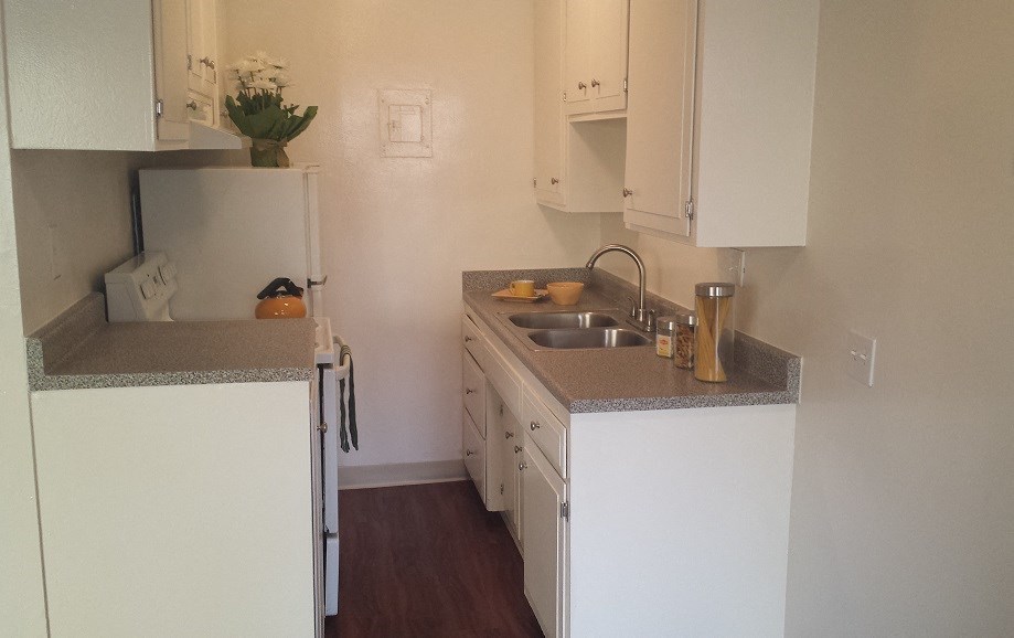 a small kitchen with white cabinets and a sink