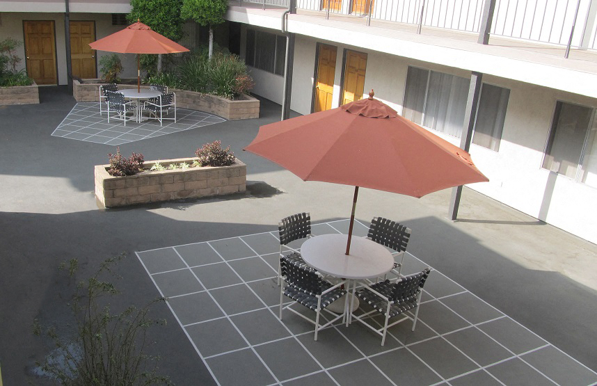 a patio with tables and umbrellas outside of a building