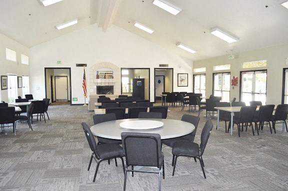 a large room with tables and chairs and a fireplace