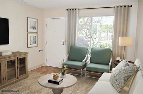 a living room with two green chairs and a white couch