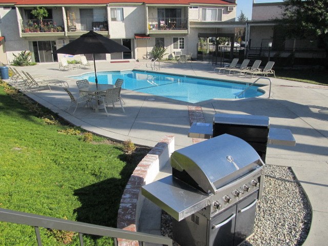 a backyard with a swimming pool and a grill