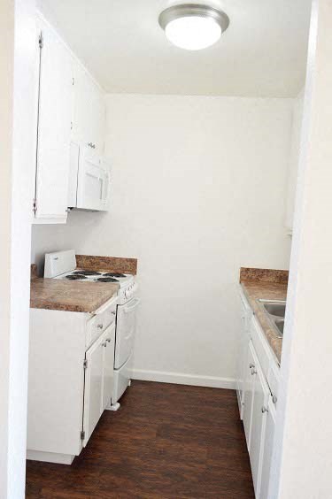 a small white kitchen with a stove and a sink