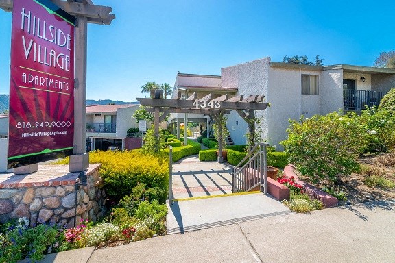 the entrance to hillside village apartments with a sign
