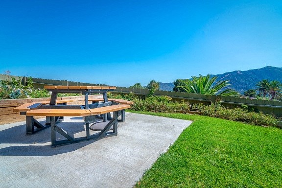 a picnic table in a backyard with a view of the mountains