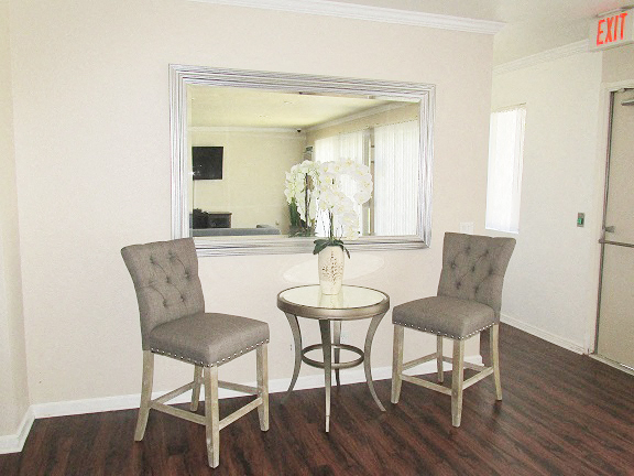a living room with two chairs and a table and a mirror