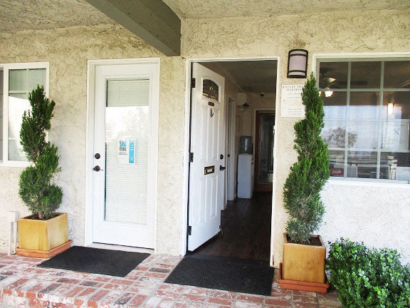 two potted plants in front of a door of a house