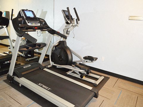 a treadmill in a gym with a white wall