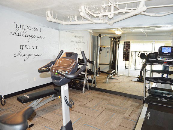 a workout room with a whiteboard and exercise equipment