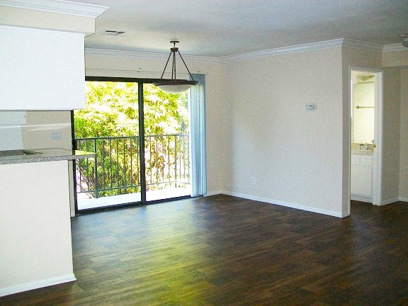 an empty living room with a door to a balcony